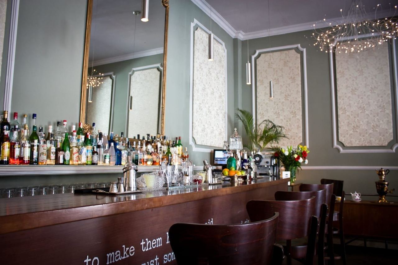 The bar at 1862 Dry Bar, with mirrors and green panelled walls