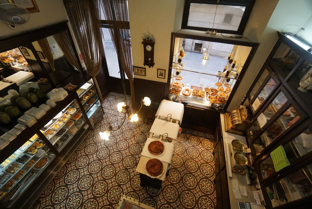 The old shop of the Antigua Pastelería del Pozo from above, with its tiled floor and wooden cabinets