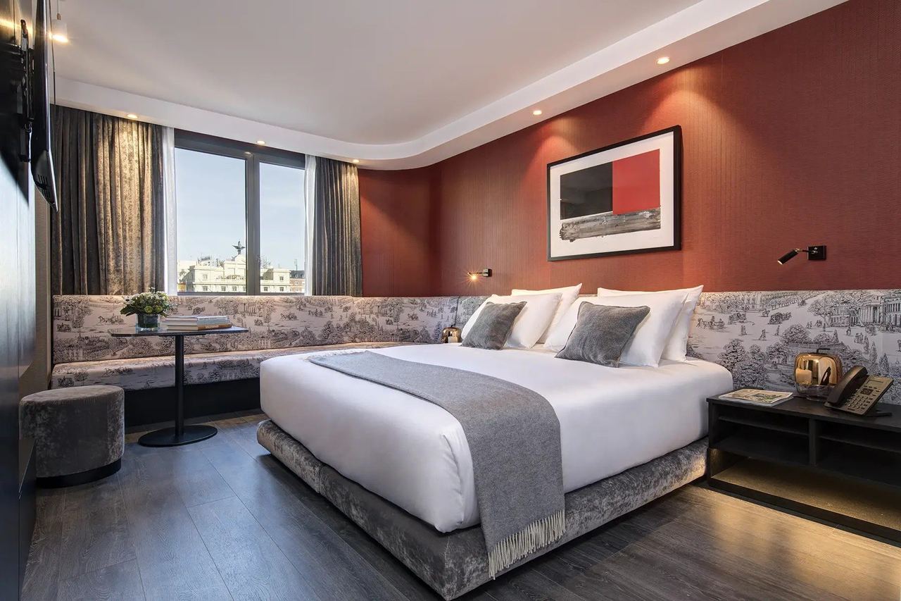 A guest room at Casa Almagro, with red walls and a toile banquette