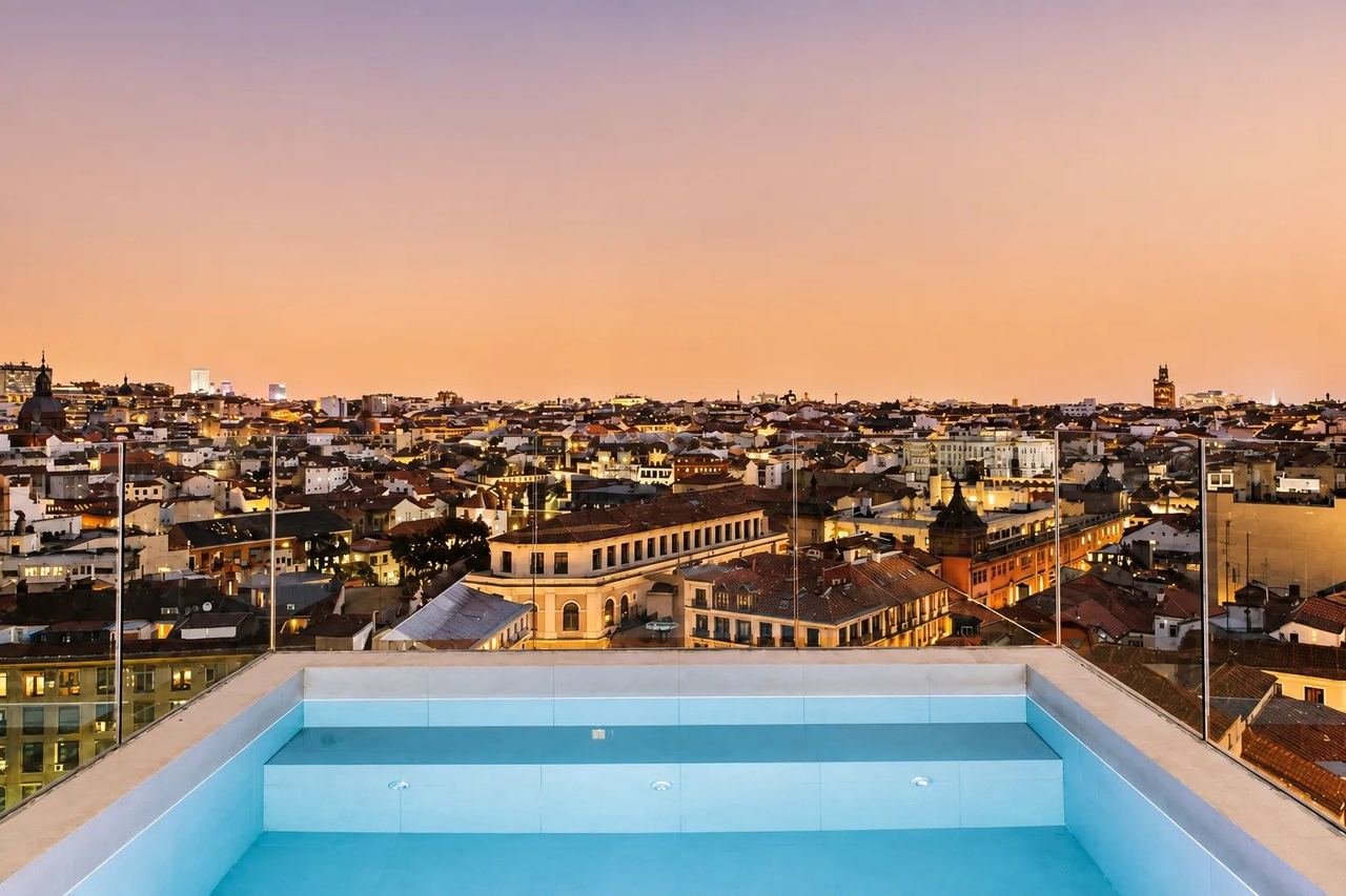 The rooftop pool of Dear Hotel Madrid at dusk, above the city