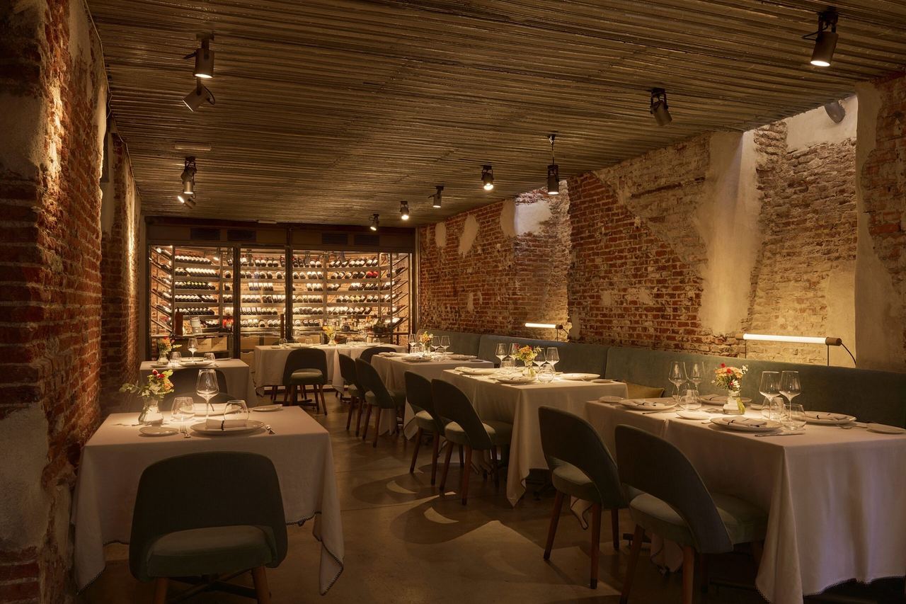 The dining room at El Señor Martín, with brick walls and a wine room