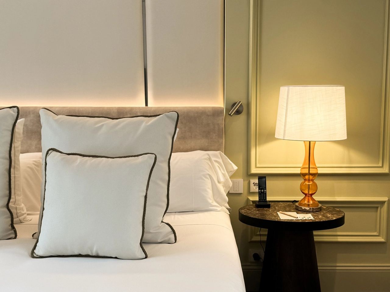 A bed and brass lamp at Hospes Puerta de Alcalá