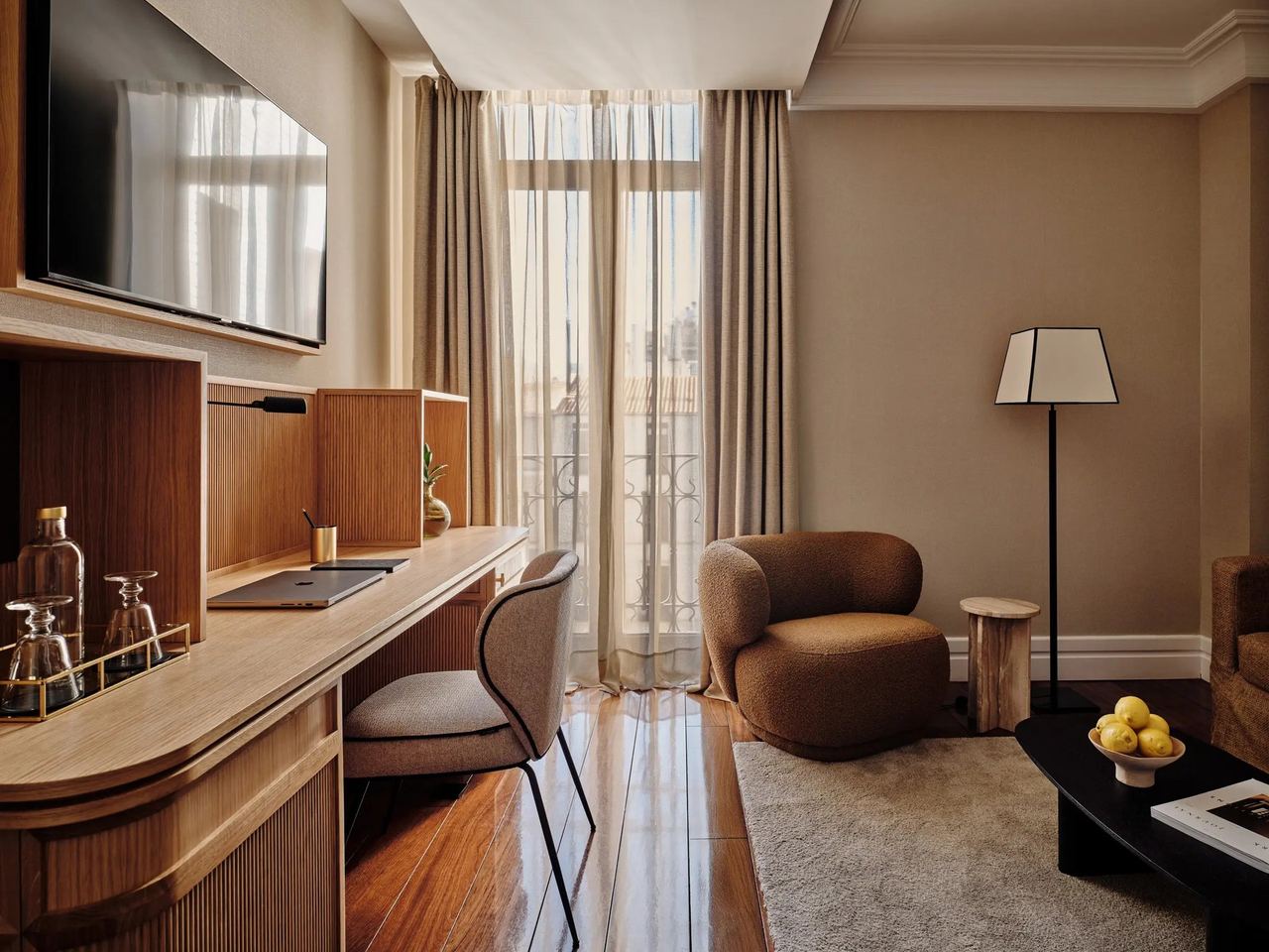 A guest room at Hotel Único, with a wooden desk and tall windows