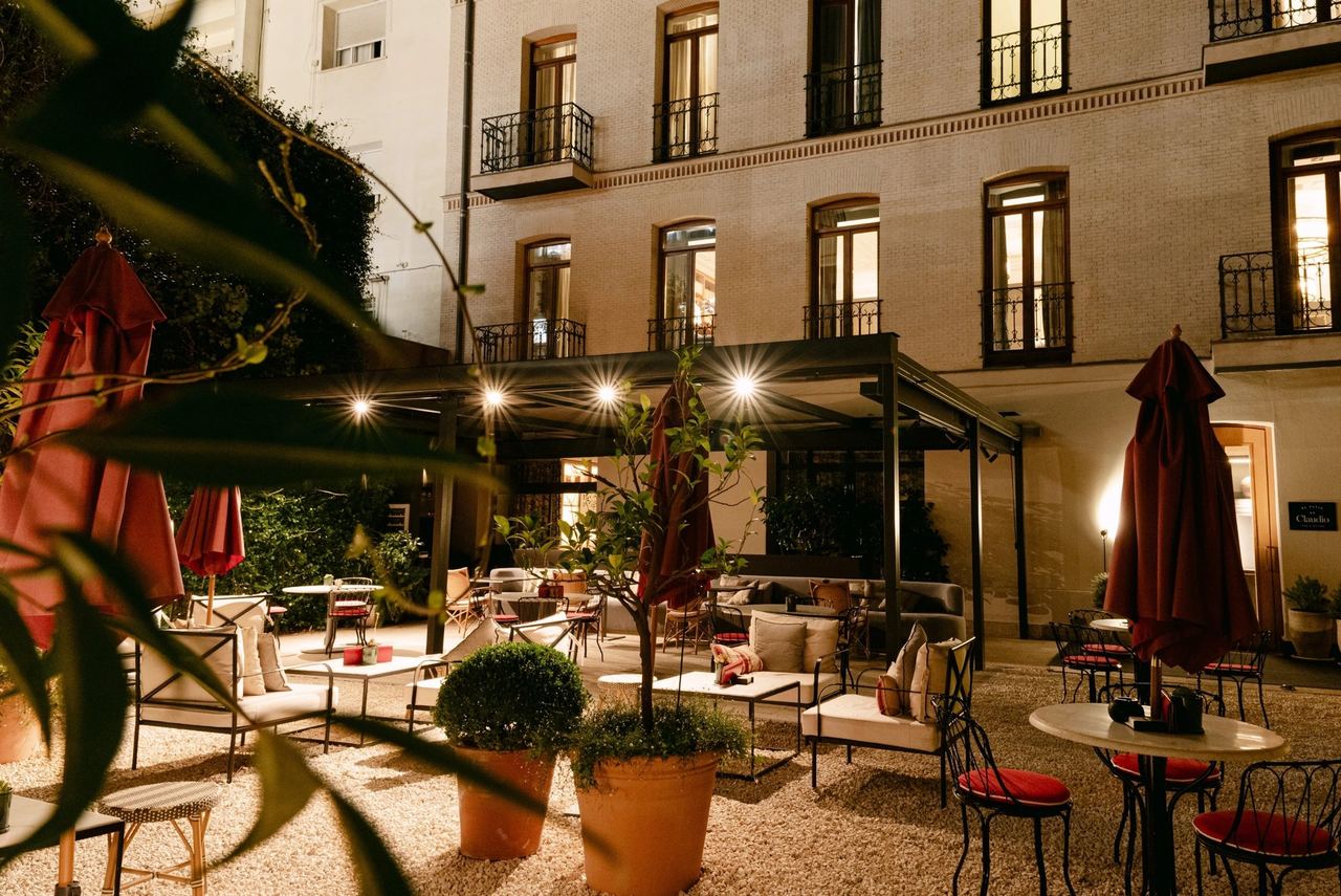 The garden courtyard of Hotel Único at dusk, with lanterns and parasols