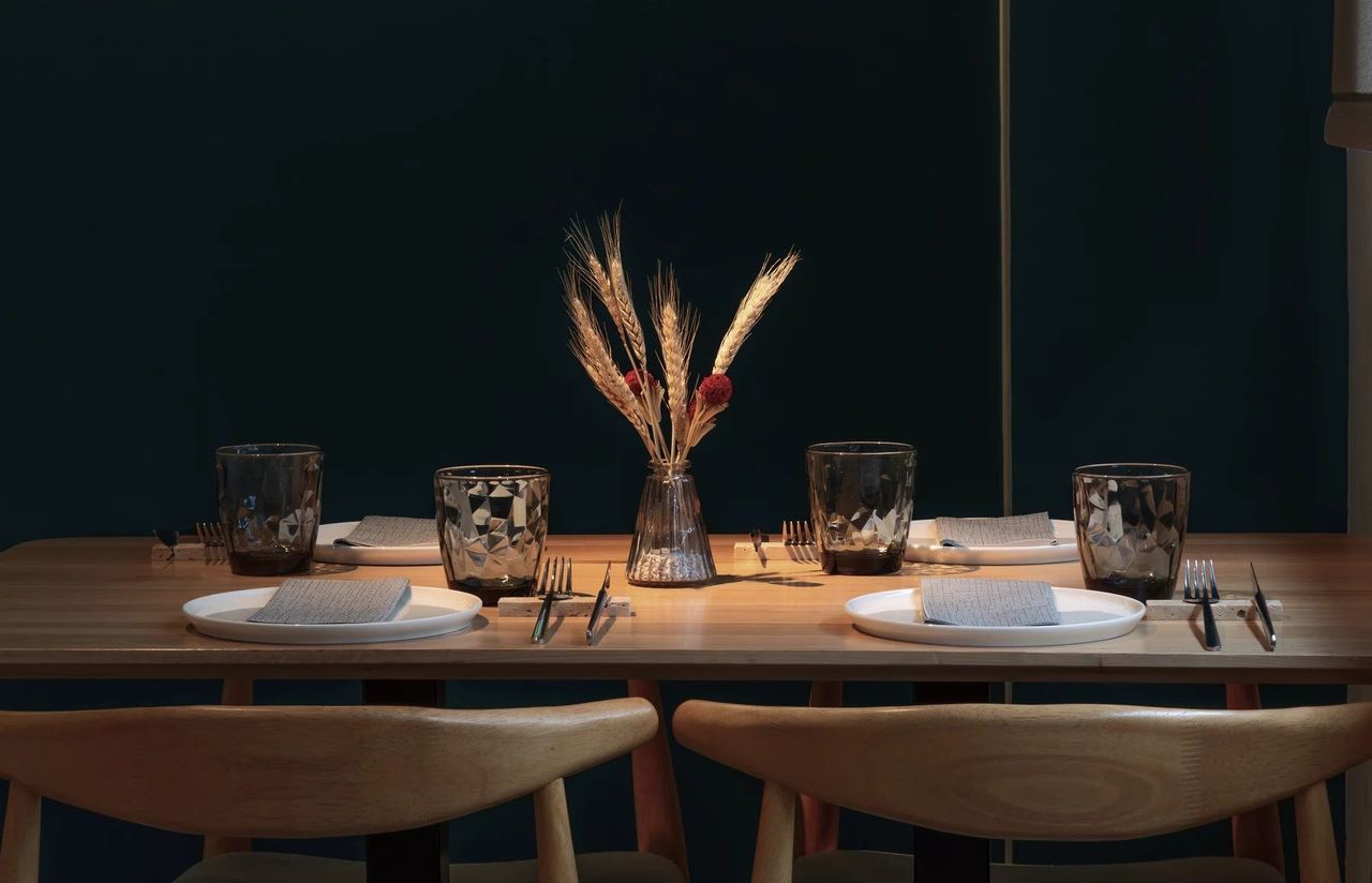 A table laid at In-Pulso, with dried wheat in a vase