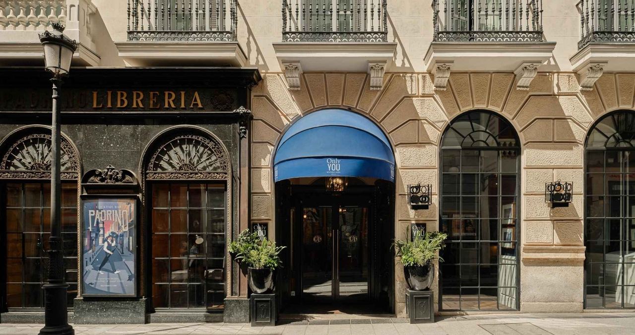 The entrance of Only YOU Boutique Hotel Madrid on Calle del Barquillo, under a blue awning