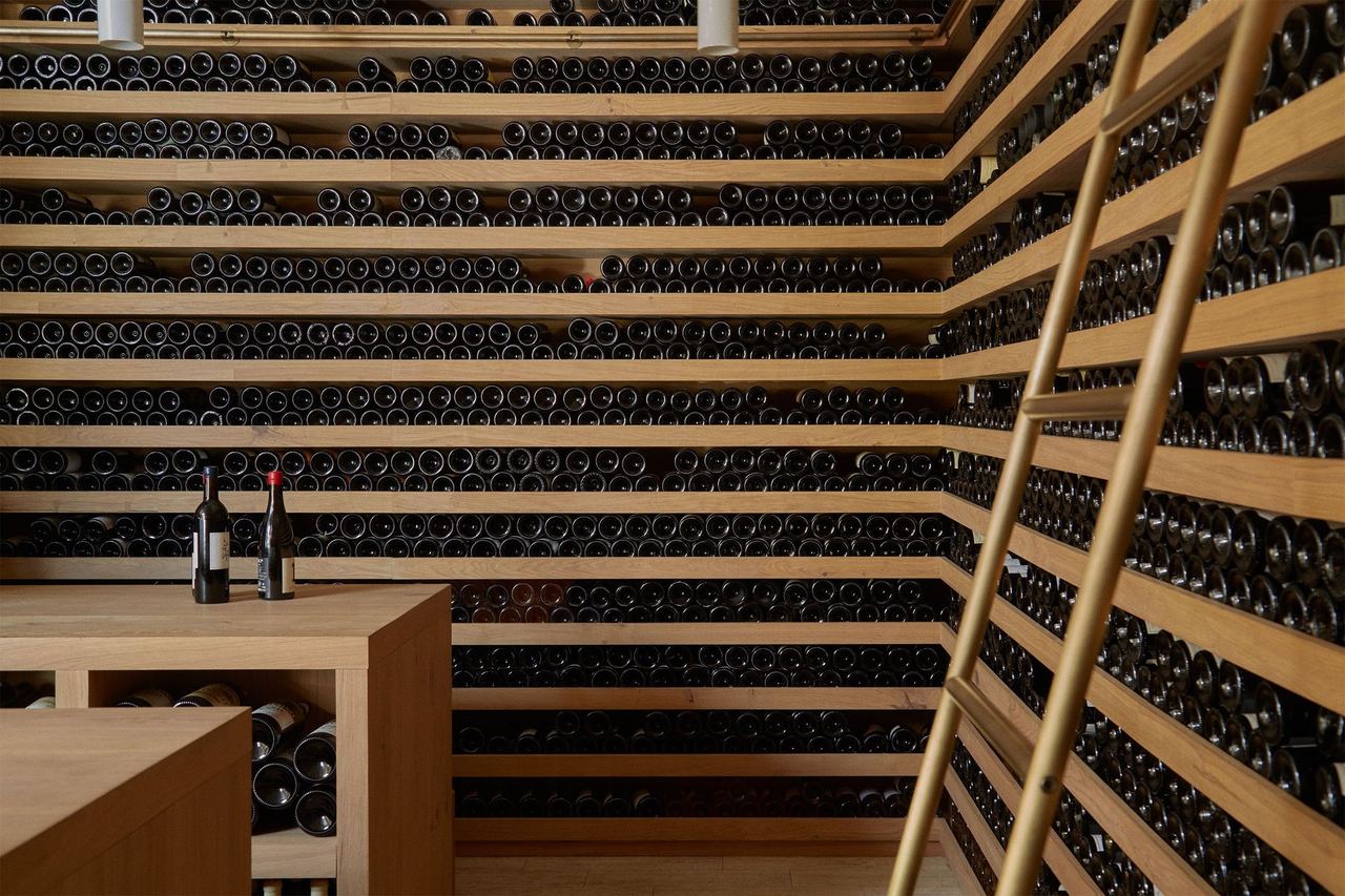 The wine cellar at OSA, with wooden racks and a ladder