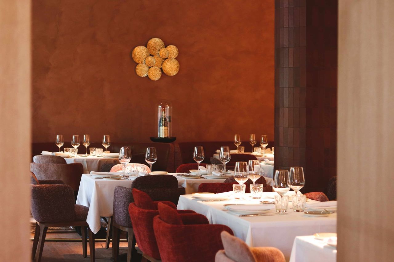 The dining room at Rocacho Plaza, with terracotta walls and red chairs