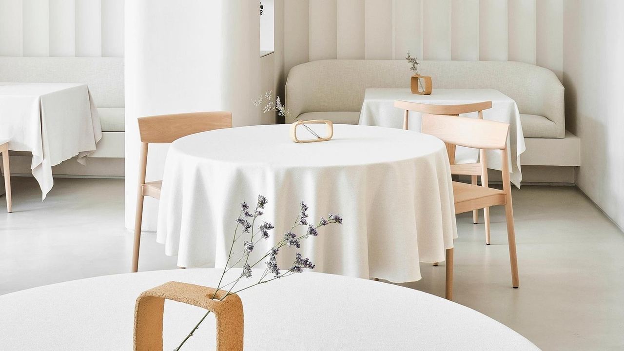 The white dining room at VelascoAbellà, with round tables and linen