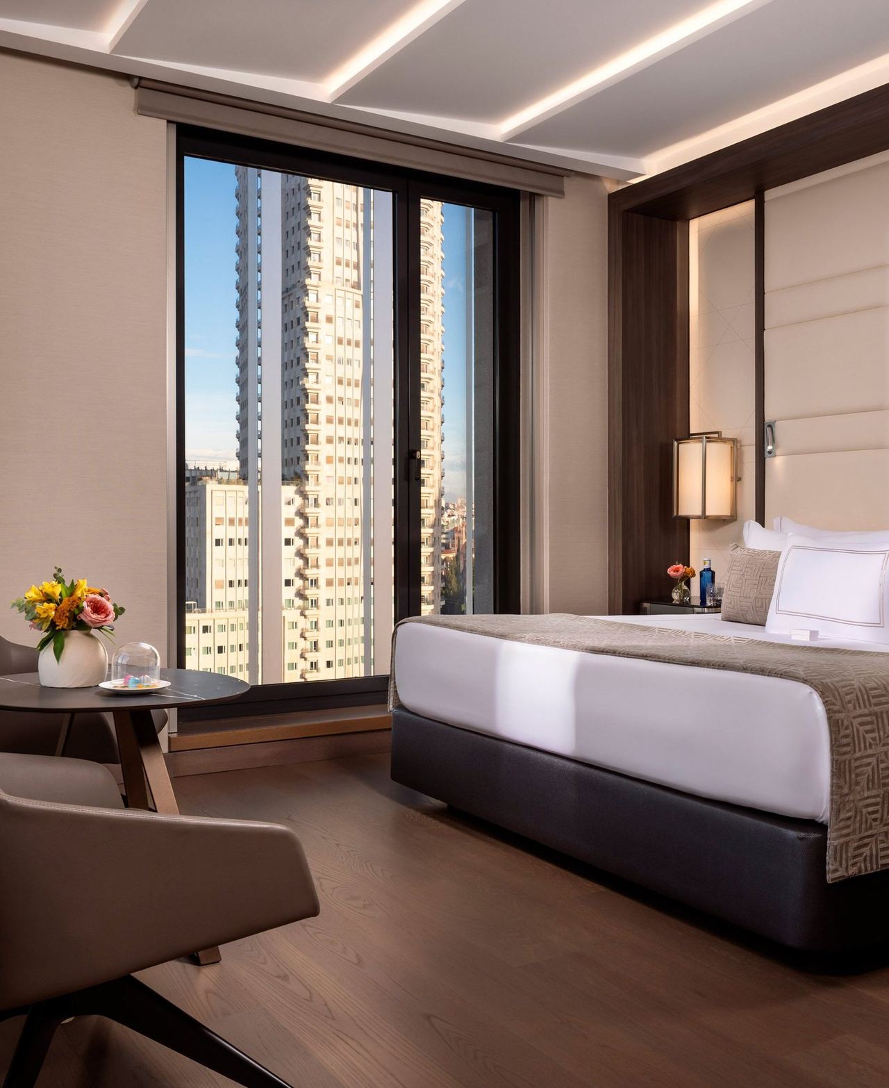 A guest room at VP Plaza España Design, with floor-to-ceiling windows on the skyline